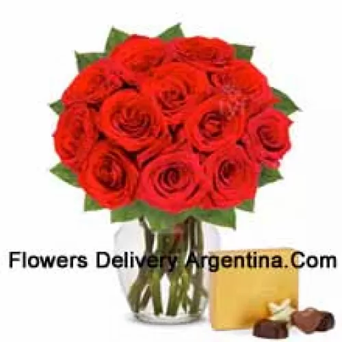 12 Red Roses With Some Ferns In A Glass Vase Accompanied With An Imported Box Of Chocolates