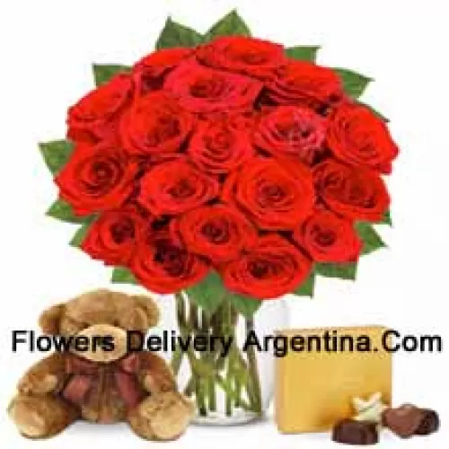 12 Red Roses With Some Ferns In A Glass Vase Accompanied With An Imported Box Of Chocolates And A Cute 12 Inches Tall Brown Teddy Bear