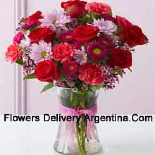 Red Roses, Red Carnations And Other Assorted Flowers Arranged Beautifully In A Glass Vase