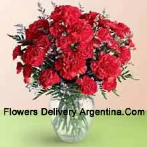 36 Red Carnations With Seasonal Fillers In A Glass Vase